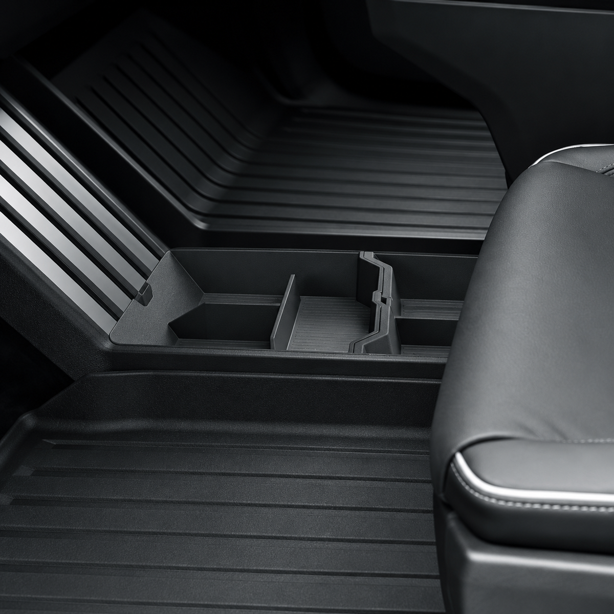Normal Cybertruck lower-console box and mat installed below the center console; text-free detail image
