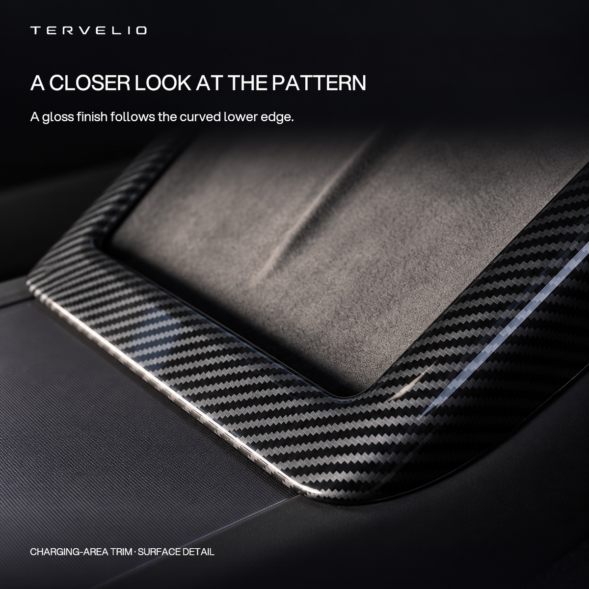 Close-up of the gloss carbon-pattern finish on the lower curve of the charging-area trim.