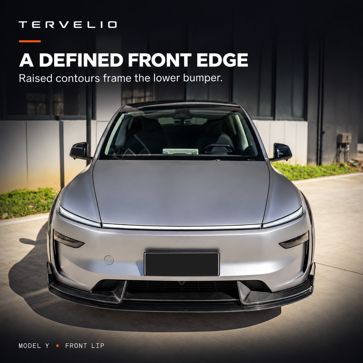 Front lip installed on the supplier-photographed silver Model Y, showing raised contours along the lower bumper.