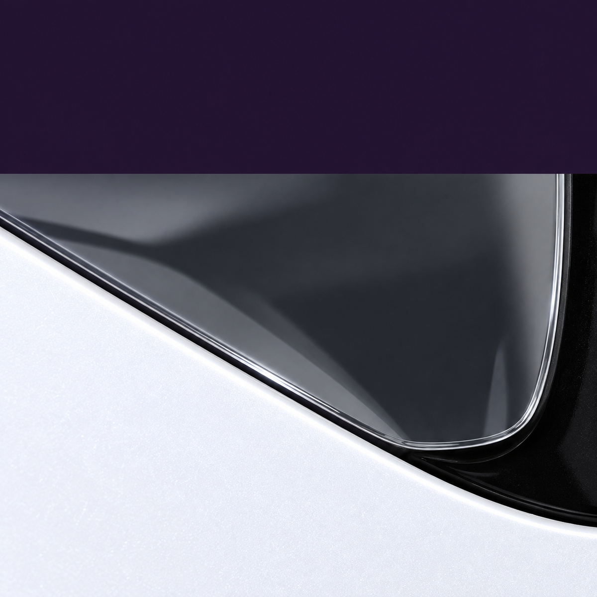 Close-up of the thin translucent sheet's curved edge beside the black port surround and white body panel.