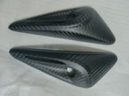 Pair of exterior camera trim covers with circular lens openings on protective foam