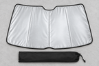 Silver windshield sunshade and black pouch lying flat on a grey work surface