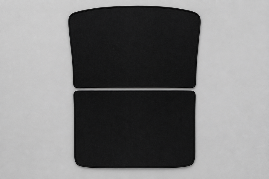Two black split roof sunshade panels lying flat on a grey inspection surface