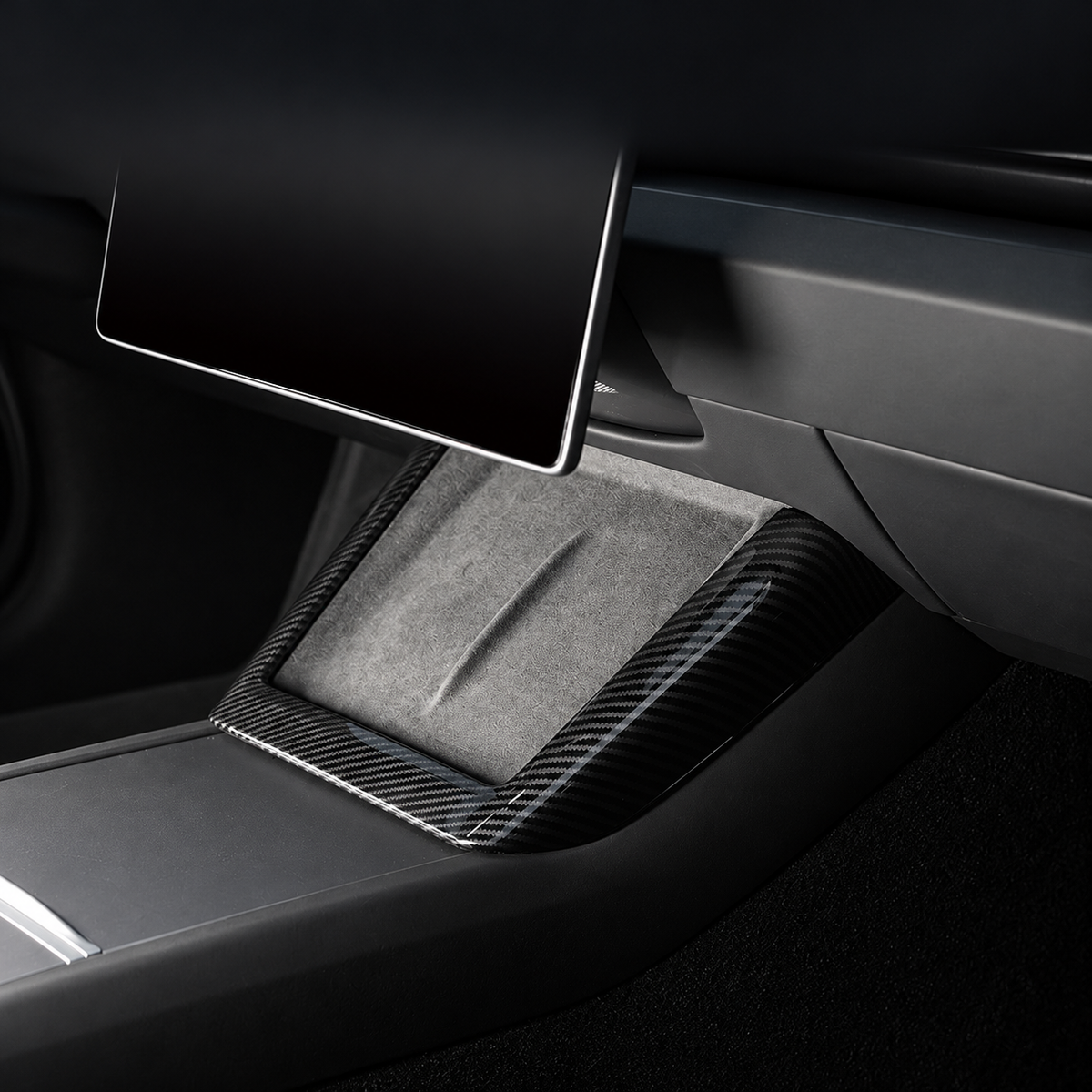 Gloss carbon-pattern U-shaped trim surrounding the console charging pad, without text overlay.