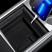 Phone and cable placement beside the flocked console tray divider; demonstration accessories are not included.