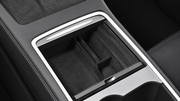 Wide view of a dark flocked organizer fitted inside the center console, showing its divided storage layout.