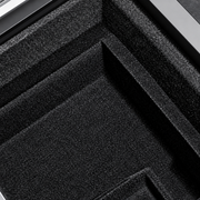 Macro view of the flocked lining and raised divider inside the dark console organizer.