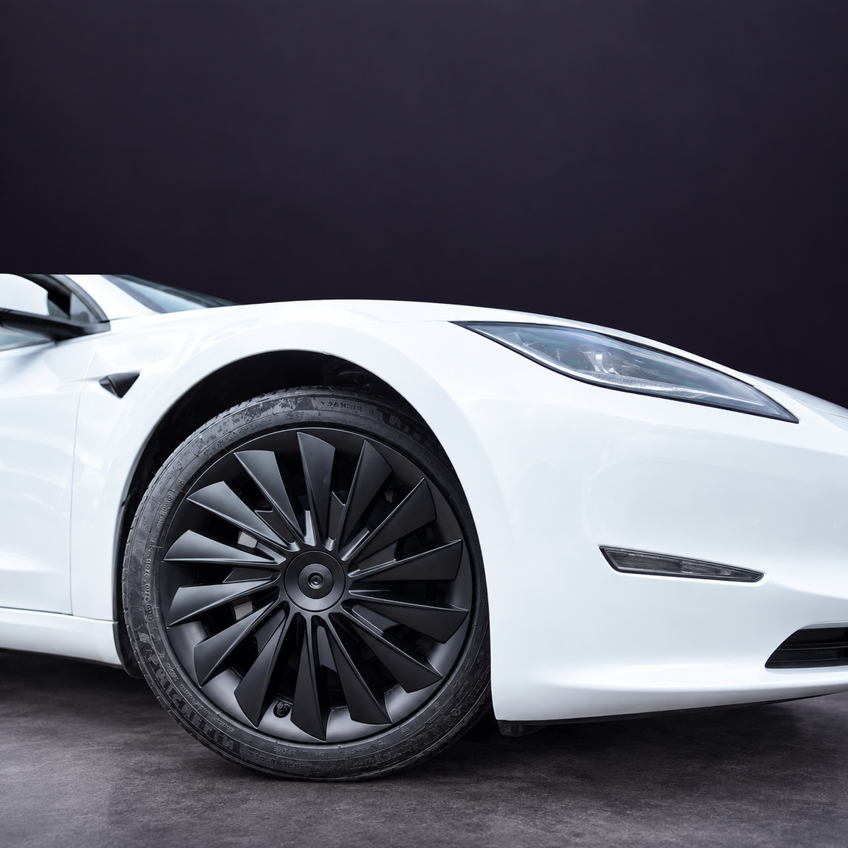 Matte-black multi-spoke wheel cover shown fitted on a supplier-photographed white vehicle.